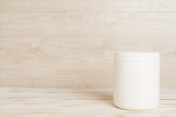 Plastic bottle for vitamins on wooden table