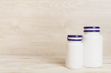 Plastic bottles for vitamins on wooden table