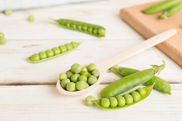 Composition with fresh green peas on wooden table