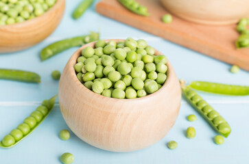 Composition with fresh green peas on wooden table