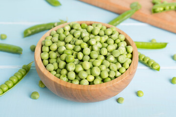 Composition with fresh green peas on wooden table