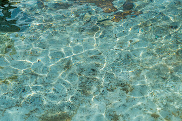 The texture of clear water illuminated by the rays of the sun.