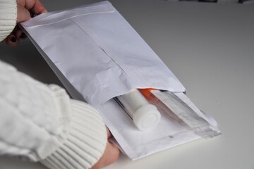 A woman opens a bag containing test tubes for cancer testing.