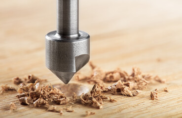 Countersink drill bit with steel triangle ruler make sink in hole for screw in wooden oak plank