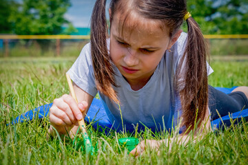 Conceptual image: Obsessive-compulsive disorder (OCD). Young beautiful girl paints the grass green...