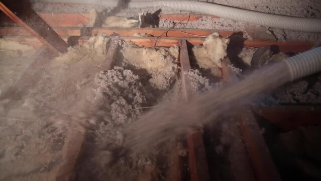 Attic being insulation with blown-in cellulose insulation.