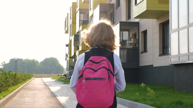 Little girl with backpack going to school, slow motion. School girl rushing to classes in the morning