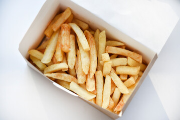 French fries in a cardboard box. Fast food. Fried potatoes. A delicious snack.