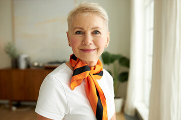 Closeup portrait of happy retired blonde stylish elegant attractive female in casual clothes with...