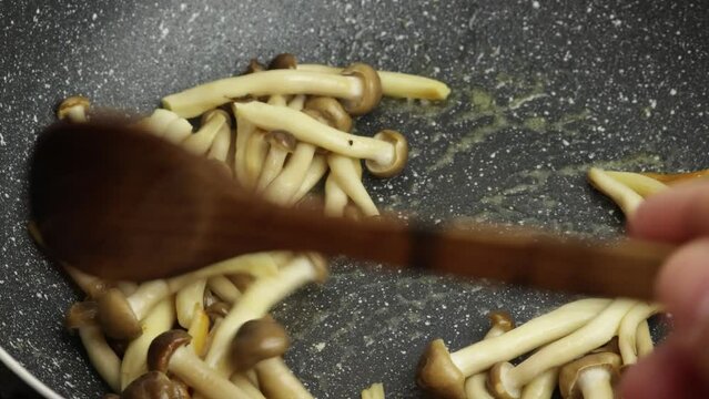 groupe de champignons bruns bunas Himeji cuisant dans une po&ecirc;le