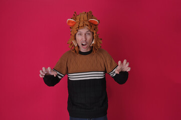 homem engraçado cômico com fantasia de leão com garras em fundo rosa 