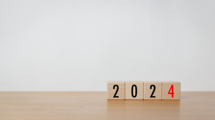 Wood cube block with 2024 text on wooden table with white background. New year goal, action plan, business plan, finance and marketing strategy concept.