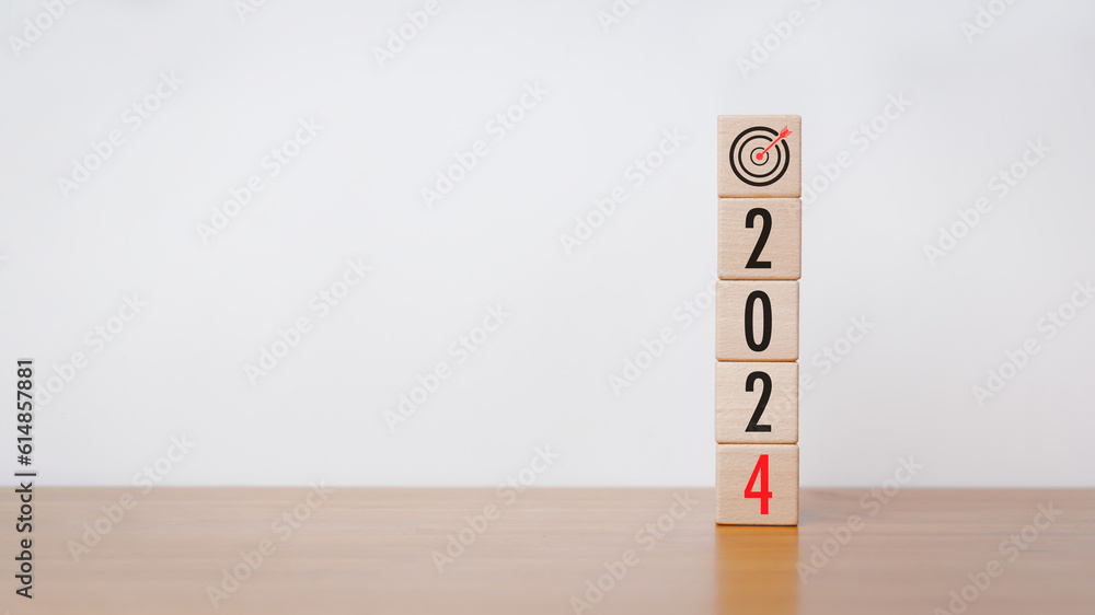 Poster wood cube block with 2024 text and arrow icon on wooden table with white background. new year goal, 