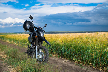 a motorcycle on the rural road in front of agriculture field of gold wheat