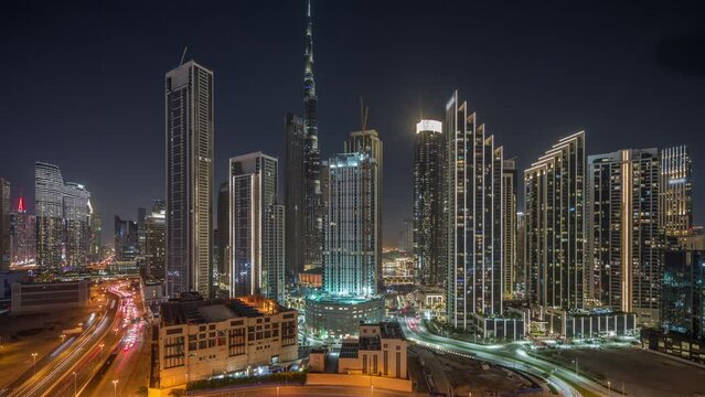 Aerial view of Dubai Downtown skyline during light show with many illuminated towers night timelapse. Business area in smart urban city. Skyscraper and high-rise buildings from above, UAE.