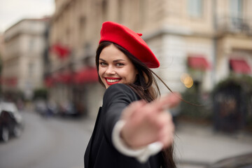 Fashion woman smile with teeth standing on the street in front of the city tourist follow me stylish clothes with red lips and red beret, travel, cinematic color, retro vintage style, urban fashion.
