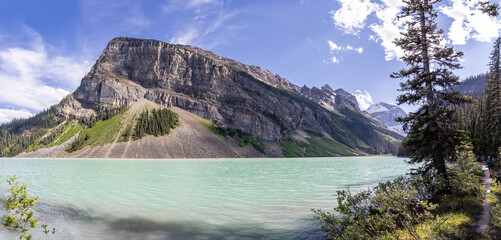 Panoramic view of Lake Louise and mountains from lake shore in Banff National Park, Alberta, Canada on 6 June 2023