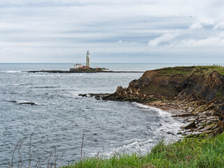Fototapeta na wymiar Erosion of cliffs on the north east coast of England with St Mary's lighthouse