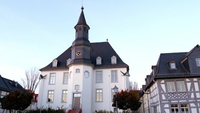 Usingen, Germany, November 2021: European medieval architecture of modern city in half-timbered style, beautiful palace, white town hall, concept of cultural tourism, travel, excursions in old town