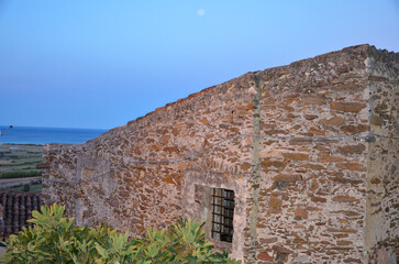 Fototapeta na wymiar Old stone building in a mountain village in Sardinia with view towards the Mediterranean Sea during dusk