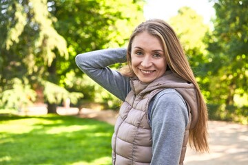 Obraz premium Joyful middle-aged woman, radiating happiness while posing in the park.