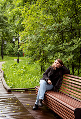 Fototapeta premium young woman walking in the park in the summer in rainy weather