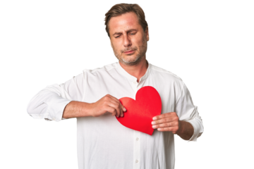 Middle-aged gentleman radiates affection holding a paper heart, in this sentimental studio portrait.