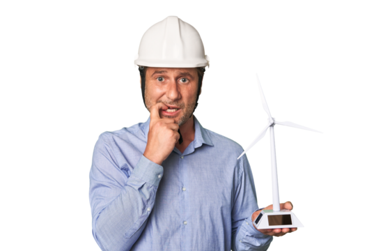 A middle-aged architect man holding a windmill model biting fingernails, nervous and very anxious.