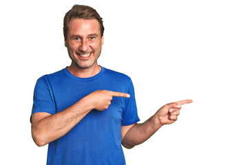 A middle-aged man isolated excited pointing with forefingers away.