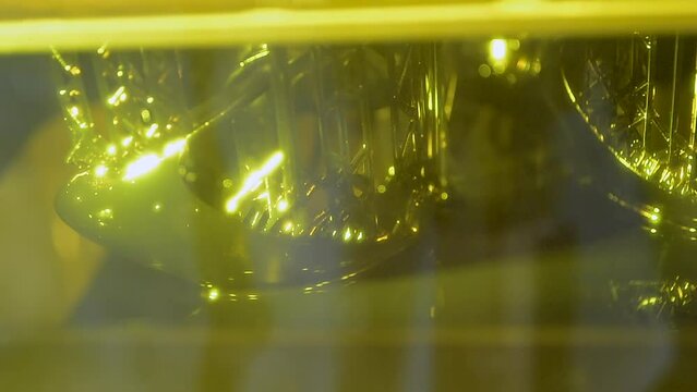 Stereolithography 3d printer. Working process 3d printer from photopolymer resins. 3D printing technology on solidification of liquid material under laser. DPL SLA 3d print UV polymerization close-up