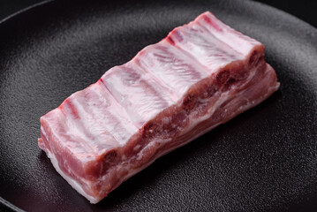 Raw pork ribs with meat with salt, spices and herbs