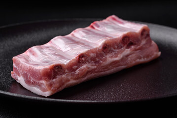 Raw pork ribs with meat with salt, spices and herbs