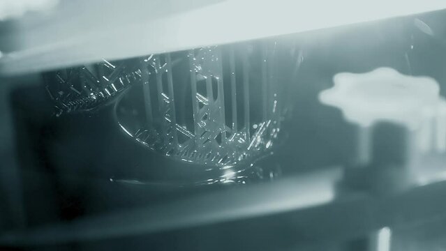 Stereolithography 3d printer. Working process 3d printer from photopolymer resins. 3D printing technology on solidification of liquid material under laser. DPL SLA 3d print UV polymerization close-up