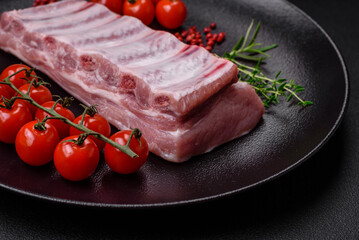 Raw pork ribs with meat with salt, spices and herbs