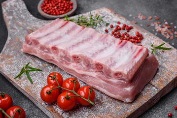 Raw pork ribs with meat with salt, spices and herbs