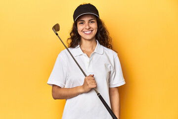 Golfer woman with cap, golf polo, yellow studio, happy, smiling and cheerful.