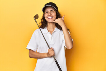 Golfer woman with cap, golf polo, yellow studio, showing a mobile phone call gesture with fingers.