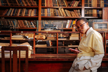 Student using cellphone in library.