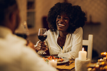 Smiling african american woman celebrating anniversary or Valentines day with her partner at home