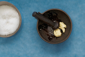 Metal mortar with crushed garlic and oil in the kitchen.2