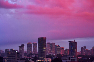 Fototapeta premium An incredible pink and purple sunset over a modern big city