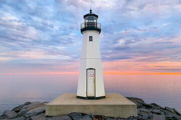 Sandspit Park Lighthouse and fishing pier in Patchogue New York, Long Island, with colorful sunset clouds and colors
