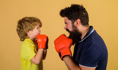 Little kid boxer with coach at boxing training. Child with boxing trainer ready to sparring. Boy...