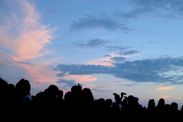 Fototapeta premium silhouettes of people on the beach at night a celebration of colors and a party.