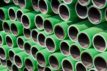 Green rubber pipes on construction as background.