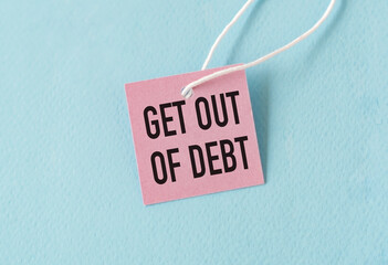 On the table are paper clips, note paper with text - Get out of debt