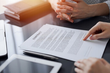 Business people discussing contract signing deal while sitting at the glass table in office, closeup. Partners or lawyers working together at meeting. Teamwork, partnership, success concept