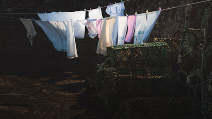 Moody atmospheric light over laundry and clothes on a clothing line hanging out to dry in a summer...