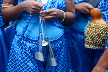 A força da cultura e da tradição refletida nas mãos femininas negras que seguram com destreza um agogô e um xequerê, instrumentos musicais emblemáticos. Uma celebração da diversidade e da música.