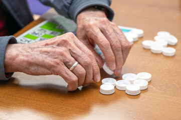 Close up of a senior man playing bingo at Nursing home. leisure game, support, assisted living, and...